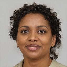 Joyful black adult female with medium  brown hair and brown eyes