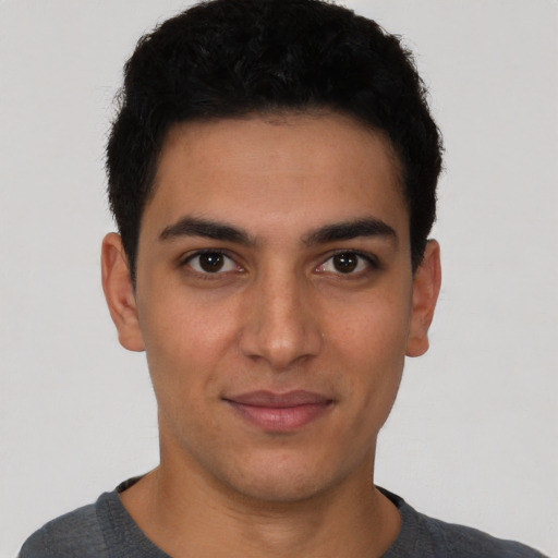 Joyful latino young-adult male with short  brown hair and brown eyes