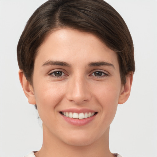 Joyful white young-adult female with short  brown hair and grey eyes