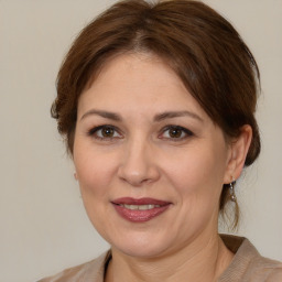 Joyful white adult female with medium  brown hair and brown eyes