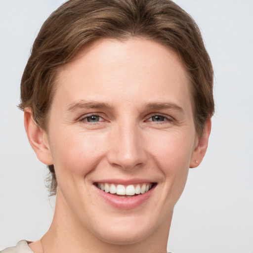 Joyful white young-adult female with short  brown hair and grey eyes