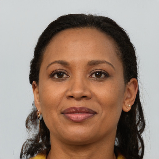 Joyful black adult female with long  brown hair and brown eyes