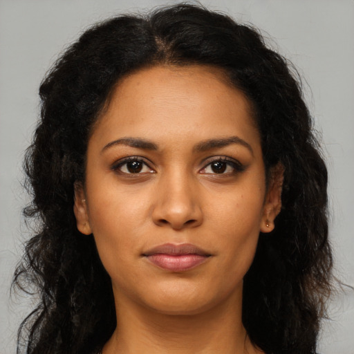 Joyful black young-adult female with long  brown hair and brown eyes