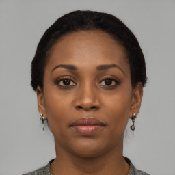 Joyful black young-adult female with short  black hair and brown eyes