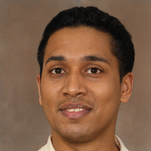 Joyful latino young-adult male with short  black hair and brown eyes