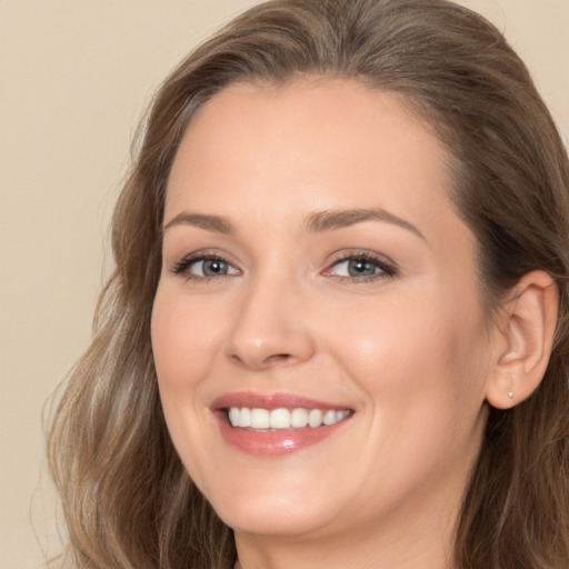 Joyful white young-adult female with long  brown hair and brown eyes