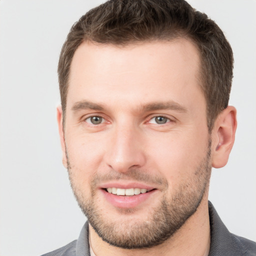 Joyful white young-adult male with short  brown hair and grey eyes