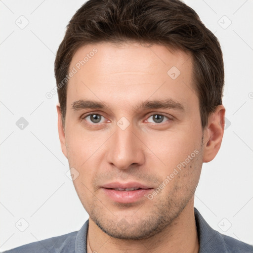 Joyful white young-adult male with short  brown hair and grey eyes