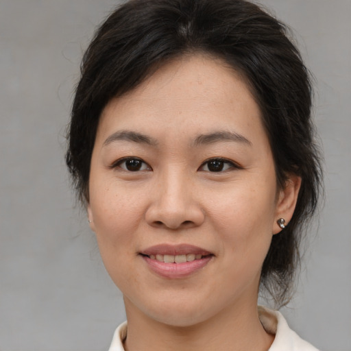 Joyful asian young-adult female with medium  brown hair and brown eyes