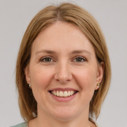 Joyful white young-adult female with medium  brown hair and green eyes