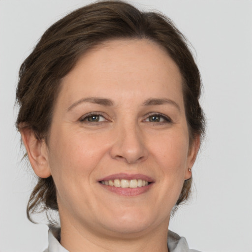 Joyful white adult female with medium  brown hair and grey eyes