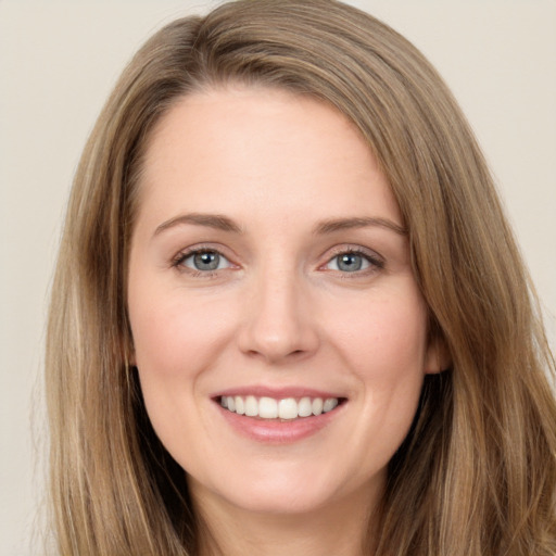 Joyful white young-adult female with long  brown hair and grey eyes