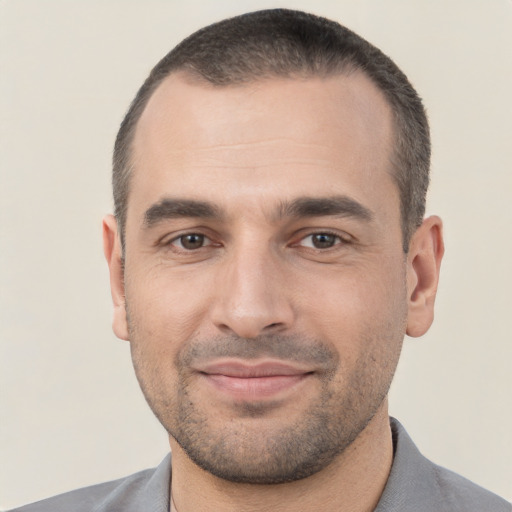 Joyful white young-adult male with short  black hair and brown eyes