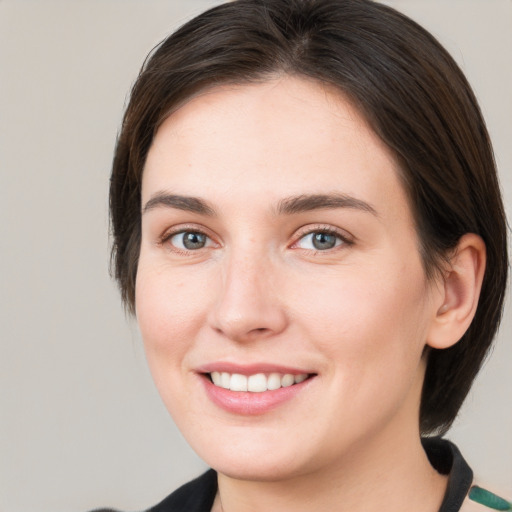 Joyful white young-adult female with medium  brown hair and grey eyes