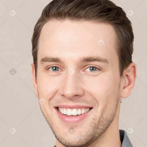 Joyful white young-adult male with short  brown hair and grey eyes