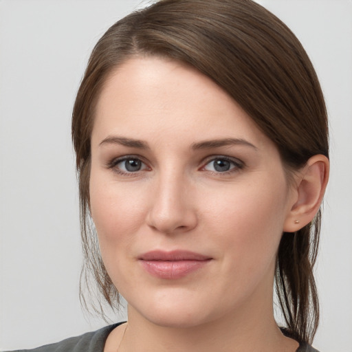 Joyful white young-adult female with medium  brown hair and grey eyes