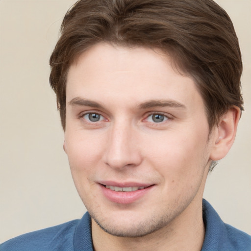 Joyful white young-adult male with short  brown hair and grey eyes