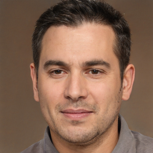 Joyful white adult male with short  brown hair and brown eyes