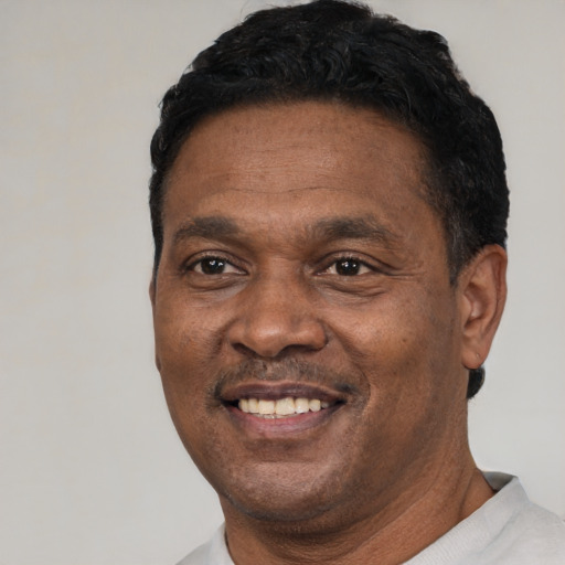 Joyful latino adult male with short  black hair and brown eyes