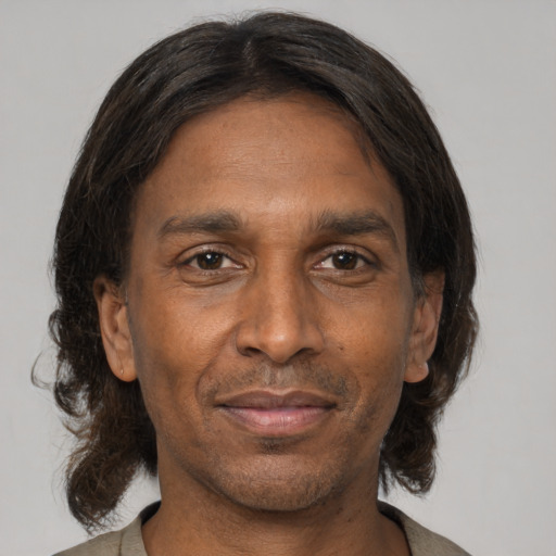 Joyful black adult male with medium  brown hair and brown eyes