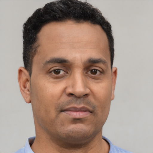 Neutral latino adult male with short  brown hair and brown eyes