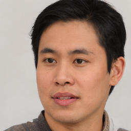 Joyful asian young-adult male with short  brown hair and brown eyes