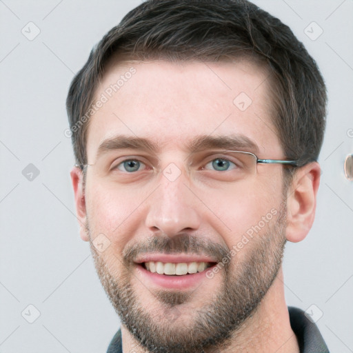 Joyful white young-adult male with short  brown hair and grey eyes