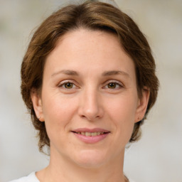 Joyful white young-adult female with medium  brown hair and green eyes