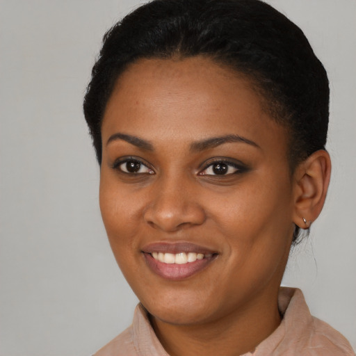 Joyful black young-adult female with short  black hair and brown eyes