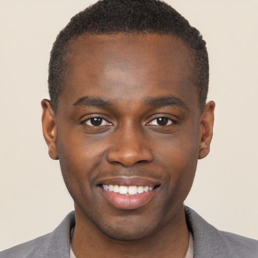 Joyful black young-adult male with short  brown hair and brown eyes