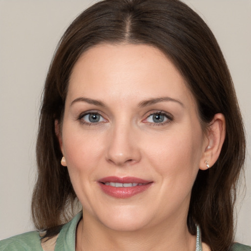 Joyful white adult female with medium  brown hair and green eyes