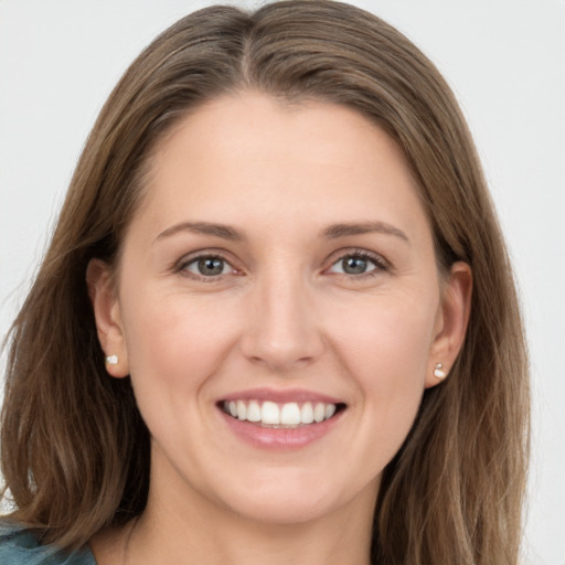 Joyful white young-adult female with long  brown hair and grey eyes