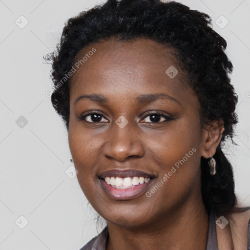 Joyful black young-adult female with long  black hair and brown eyes