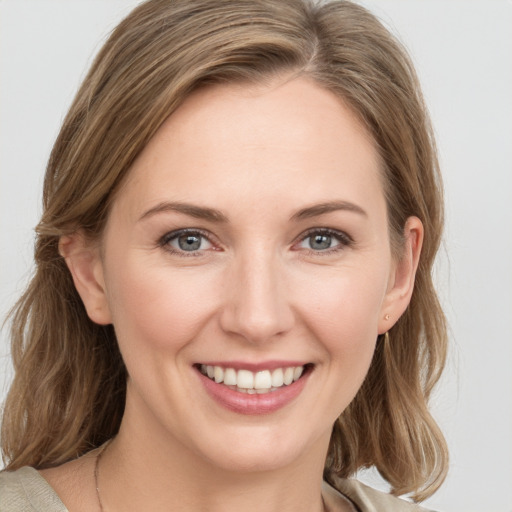 Joyful white young-adult female with medium  brown hair and blue eyes