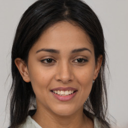 Joyful latino young-adult female with long  brown hair and brown eyes