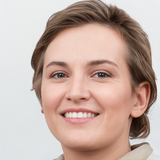 Joyful white young-adult female with medium  brown hair and grey eyes