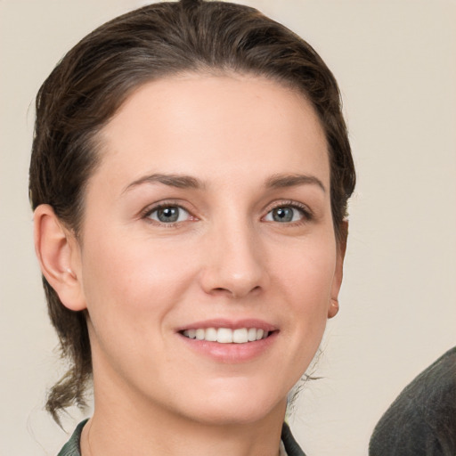 Joyful white young-adult female with medium  brown hair and grey eyes