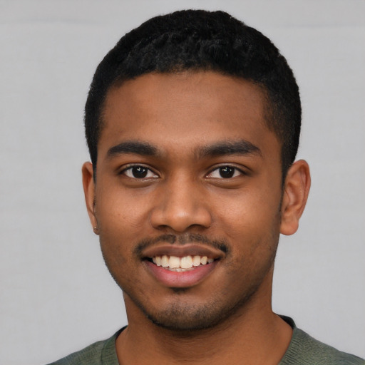 Joyful black young-adult male with short  black hair and brown eyes