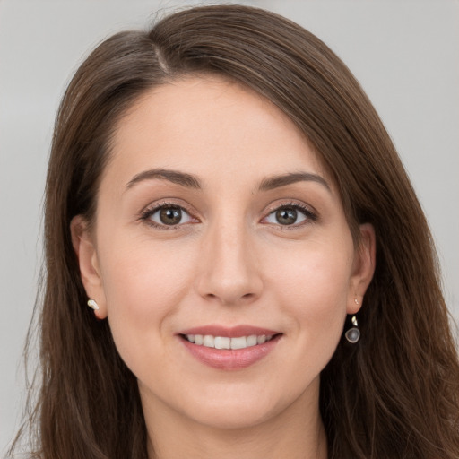 Joyful white young-adult female with long  brown hair and grey eyes