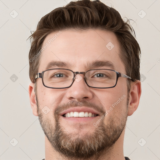 Joyful white young-adult male with short  brown hair and grey eyes