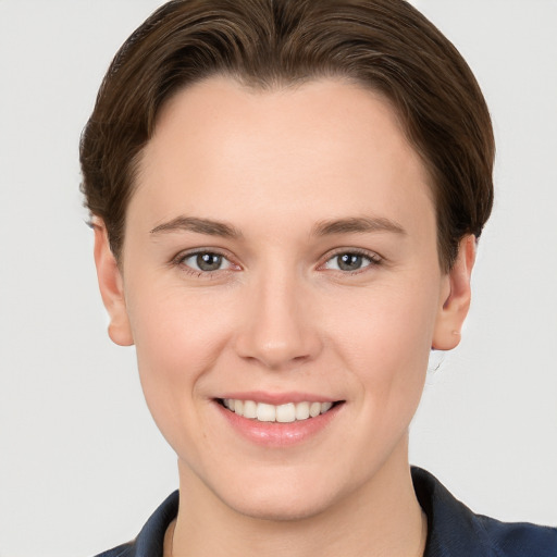 Joyful white young-adult female with short  brown hair and grey eyes