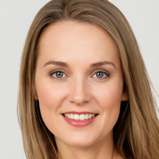 Joyful white young-adult female with long  brown hair and green eyes