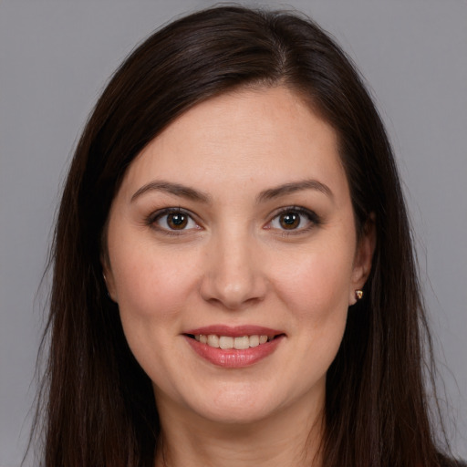 Joyful white young-adult female with long  brown hair and brown eyes