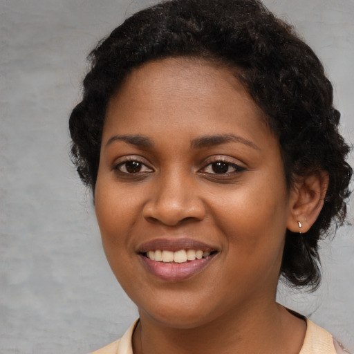 Joyful black young-adult female with short  brown hair and brown eyes