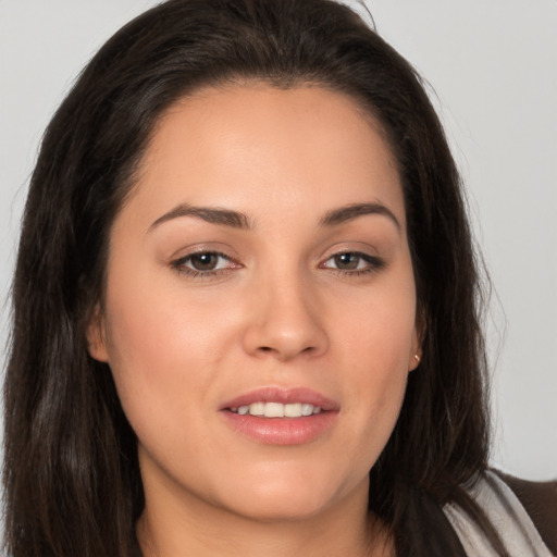 Joyful white young-adult female with long  brown hair and brown eyes