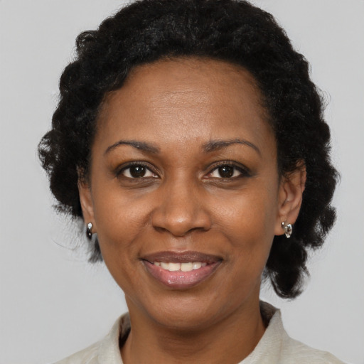 Joyful black adult female with short  black hair and brown eyes