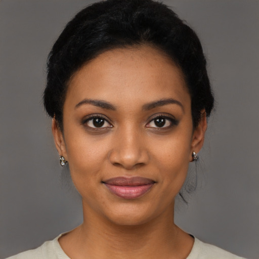 Joyful black young-adult female with short  black hair and brown eyes