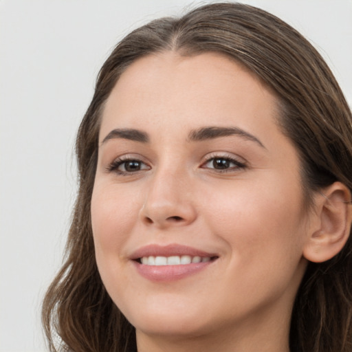 Joyful white young-adult female with long  brown hair and brown eyes