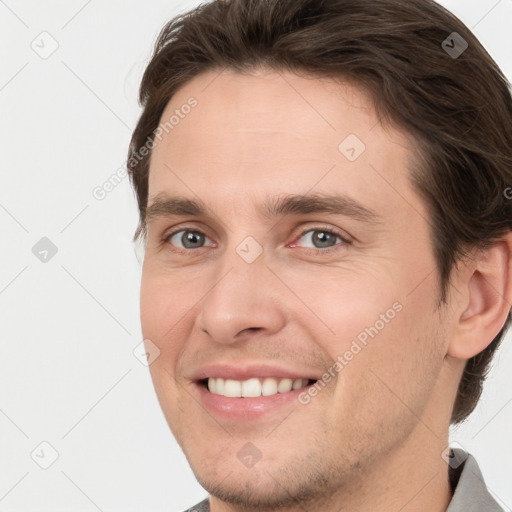 Joyful white young-adult male with short  brown hair and grey eyes