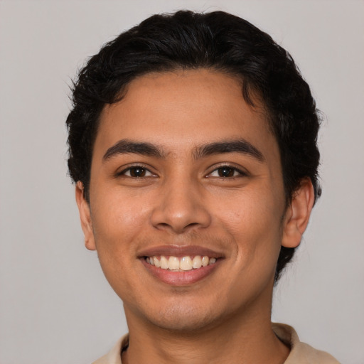 Joyful latino young-adult male with short  brown hair and brown eyes